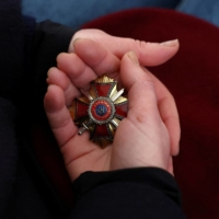 Oksana Dudar, widow of Victor, holds an honorary military medal of her husband, an army reservist who volunteered to fight and was killed following the Russian invasion, on the outskirts of Lviv, Ukraine, March 10.  | REUTERS