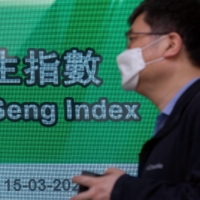 An electronic screen displays the Hang Seng Index in Hong Kong, China, on Tuesday. | BLOOMBERG
