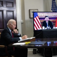 President Joe Biden takes notes during a video summit with President Xi Jinping of China at the White House in November 2021. | DOUG MILLS / THE NEW YORK TIMES