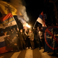 People hold Russian and Serbian flags and a picture of Russian President Vladimir Putin during a rally organized by Serbian right-wing organizations in support of the Russian invasion in Ukraine, in Belgrade on March 4. | AFP-JIJI