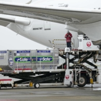 COVID-19 vaccines are loaded onto a Japan Airlines plane before its departure from Narita Airport for Taiwan on June 4. | KYODO
