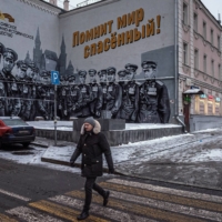 A patriotic mural in Moscow in December showing Soviet pilots from World War II, based on a photograph of the Victory Parade in 1945. The sign in Russian reads, \"The saved world remembers you!\" | SERGEY PONOMAREV / THE NEW YORK TIMES