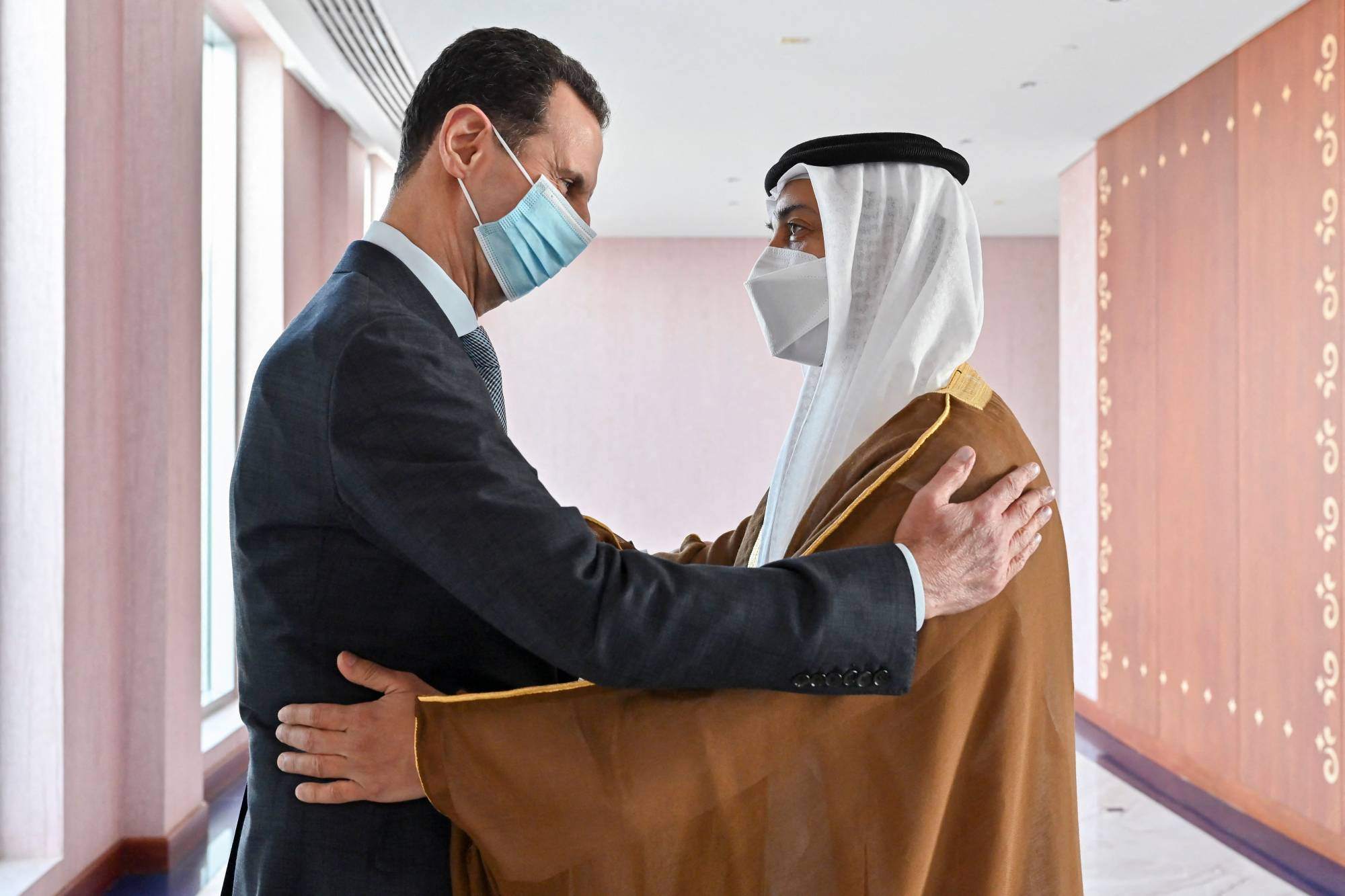 Syrian President Bashar Assad (left) is greeted by Sheikh Mansour bin Zayed Al Nahyan, UAE deputy prime minister and minister of presidential affairs, in the capital, Abu Dhabi, on Friday. | UAE's Ministry of Presidential Affairs / VIA AFP-JIJI