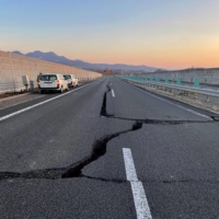 Cracks are seen on a damaged road between the Kunimi Interchange and Shiroishi Interchange on the Tohoku Expressway in Shiroishi, Miyagi Prefecture, on Thursday, after a large earthquake jolted the area the night before.  | NEXCO EAST NIPPON EXPRESSWAY COMPANY LIMITED / VIA AFP-JIJI