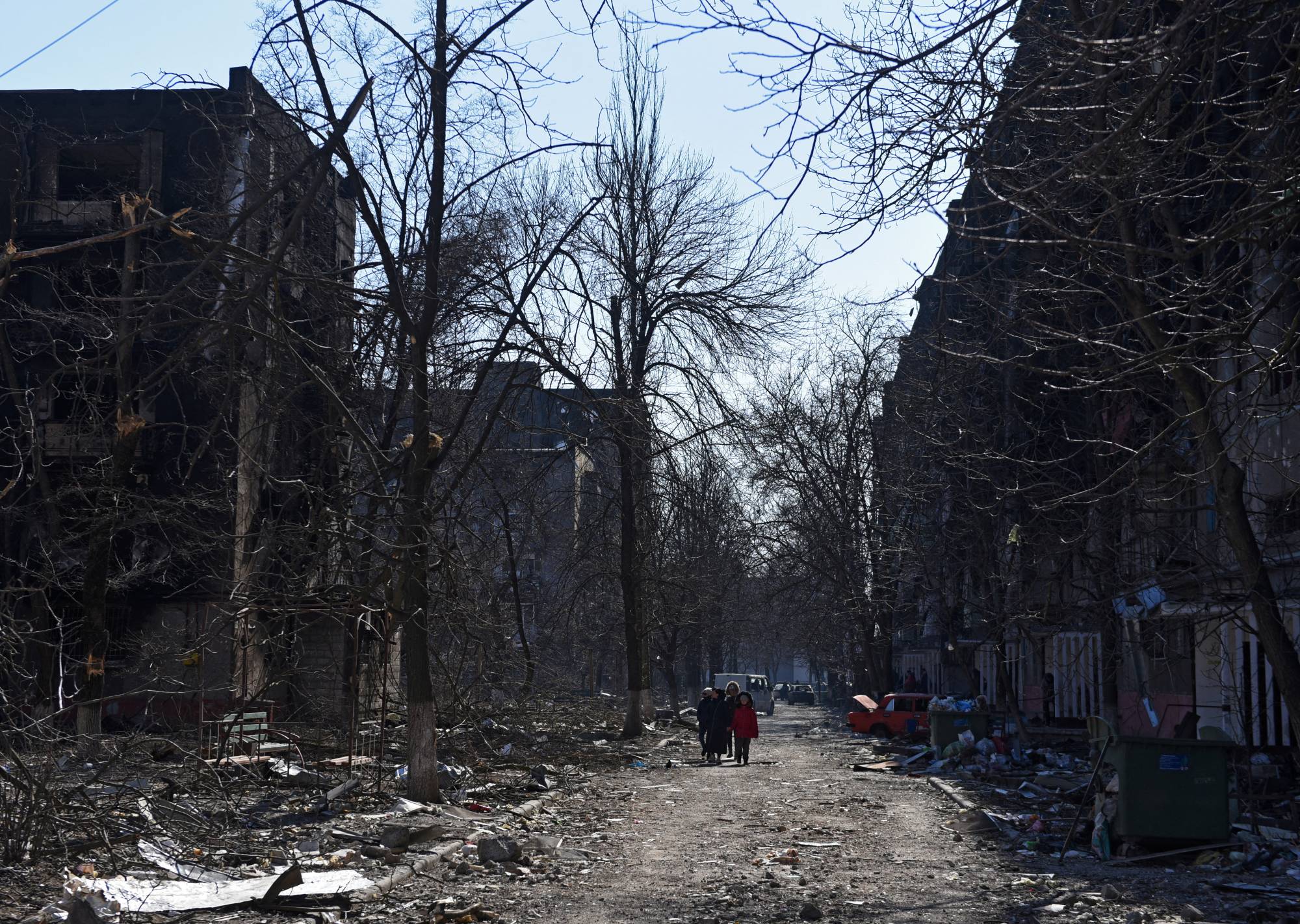 Mariupol residents near damaged residential buildings on Friday | Reuters