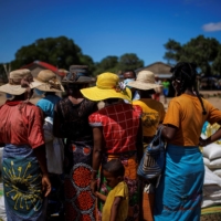 Local residents wait to get goods at a food distribution post run by the World Food Program in the Antanimora commune.  | REUTERS