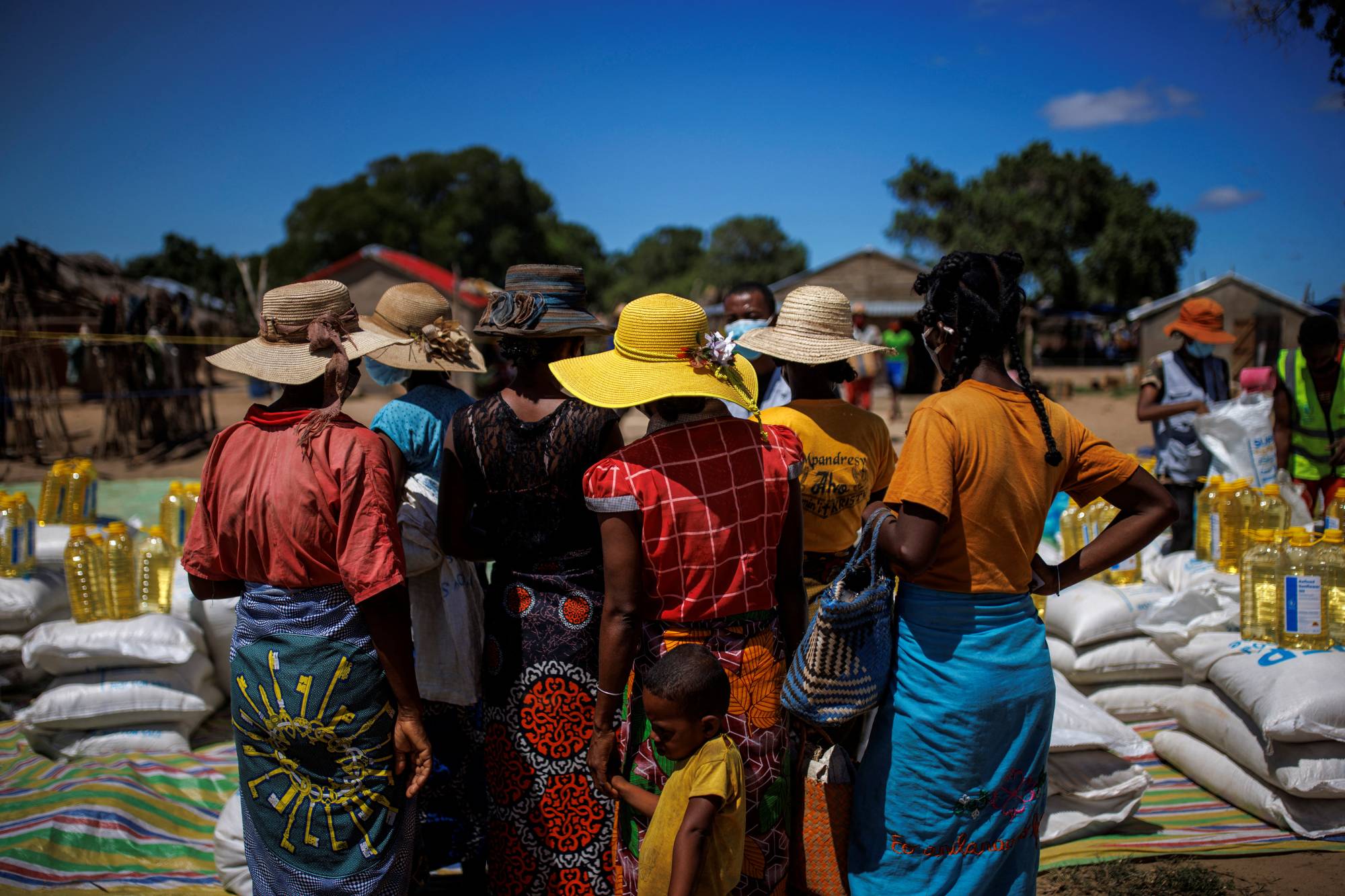 Local residents wait to get goods at a food distribution post run by the World Food Program in the Antanimora commune. | Reuters