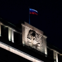 The Russian national tricolor flag flutters on top of the building of the State Duma, the lower chamber of Russia\'s parliament, in Moscow on March 3, a day before lawmakers approved legislation mandating up to 15 years in prison for any publication of fake news about the Russian armed forces.  | AFP-JIJI