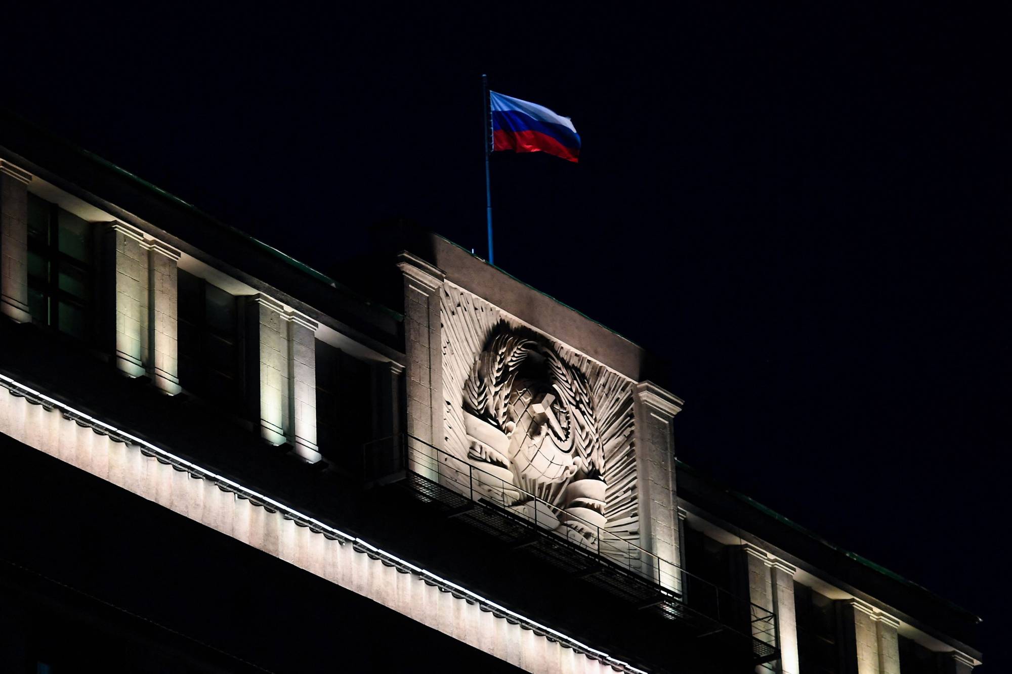 The Russian national tricolor flag flutters on top of the building of the State Duma, the lower chamber of Russia's parliament, in Moscow on March 3, a day before lawmakers approved legislation mandating up to 15 years in prison for any publication of fake news about the Russian armed forces. | AFP-JIJI
