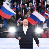 Russian President Vladimir Putin attends a concert marking the eighth anniversary of Russia\'s annexation of Crimea, in Moscow on Friday. The Kremlin has used a barrage of increasingly outlandish falsehoods to prop up its overarching claim that the invasion of Ukraine is justified. | POOL / VIA AFP-JIJI