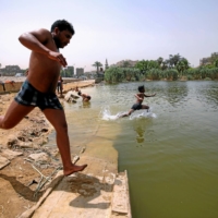 Egyptian boys jump into the Ain El-Sira groundwater lake to cool off on a hot summer day in Old Cairo, Egypt, in 2016. | REUTERS