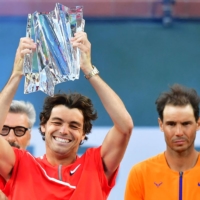 Taylor Fritz lifts the trophy after defeating Rafael Nadal (right) in their ATP Masters 1000 final in Indian Wells, California, on Sunday. | AFP-JIJI