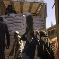 Laborers unload sacks of flour from a World Food Program convoy that traveled from Kabul to Afghanistan’s Tagab district, on Oct. 27. Aid workers warn that a humanitarian crisis has already been exacerbated by the war in Ukraine, making it more difficult to feed the roughly 23 million Afghans. | VICTOR J. BLUE / THE NEW YORK TIMES