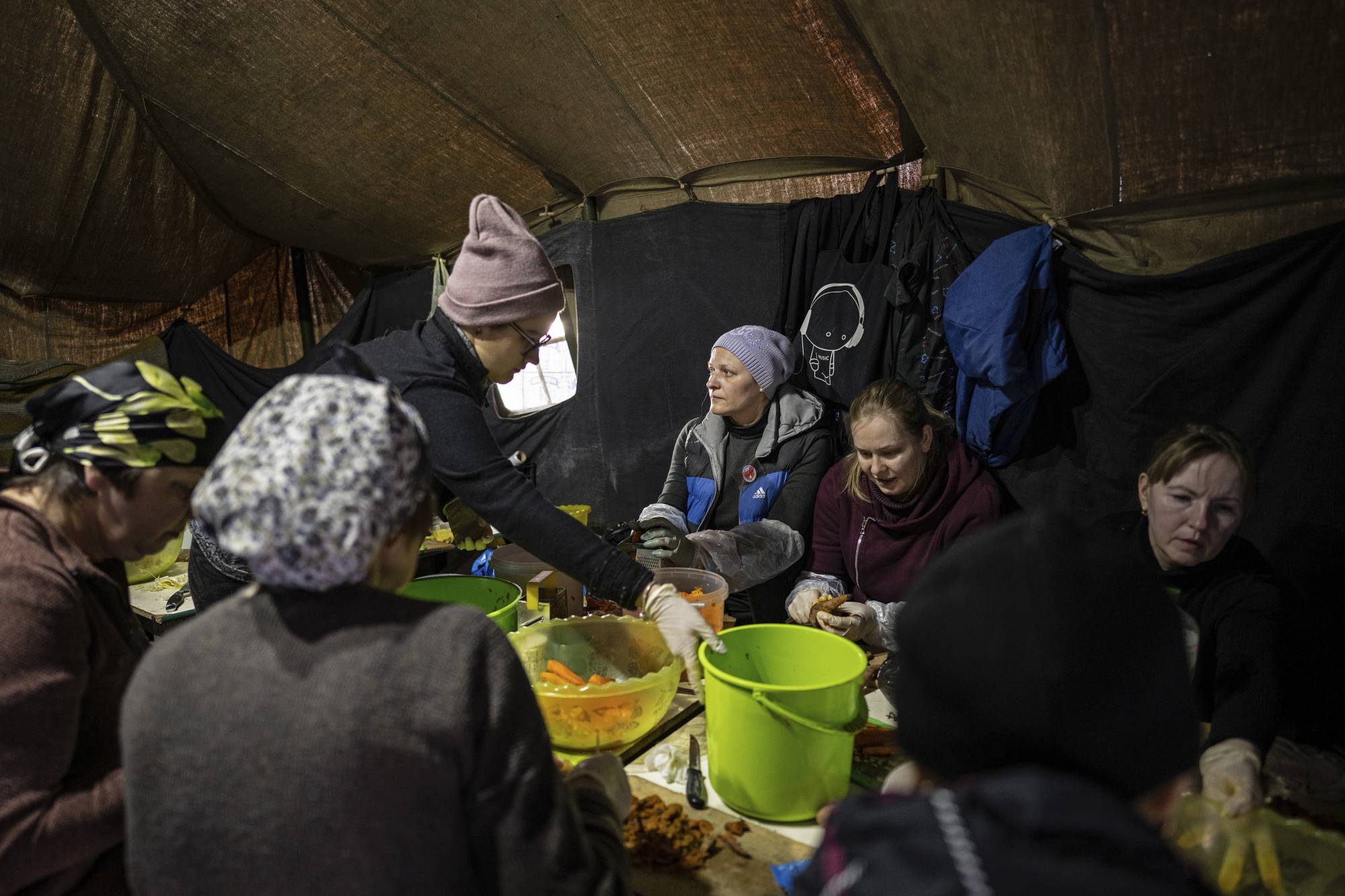 Volunteers prepare food at a market where food is cooked for thousands of people in northern Kyiv, on Tuesday. | Lynsey Addario / The New York Times