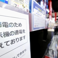 A sign at an electric appliance store in Tokyo\'s Yurakucho district tells customers some products are turned off to save electricity on Tuesday. | KYODO