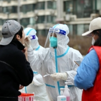 A resident undergoes a nucleic acid test for the COVID-19 coronavirus in Shenyang, in China\'s northeastern Liaoning province on March 14. | AFP-JIJI 