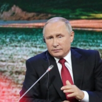 Russian President Vladimir Putin speaks as he sits beside Chinese President Xi Jinping during the second day of the Eastern Economic Forum in Vladivostok, Russia, in September 2018. | BLOOMBERG