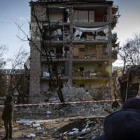 People sift through the remains of a residential complex after a strike in Kyiv on Friday. U.S. President Joe Biden warned Chinese President Xi Jinping the same day of repercussions if Beijing decides to give Russia financial or military aid to support its war in Ukraine, White House officials said, but they did not specify what those consequences would be. | IVOR PRICKETT / THE NEW YORK TIMES
