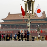 People visit Tiananmen Square, decorated with Chinese and Japanese flags, in Beijing in October 2018. | REUTERS
