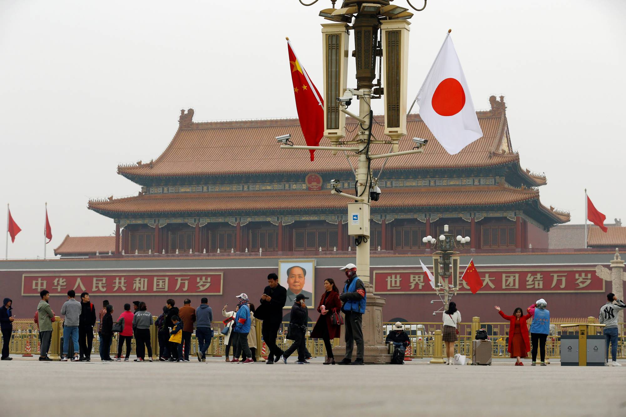 People visit Tiananmen Square, decorated with Chinese and Japanese flags, in Beijing in October 2018. | REUTERS