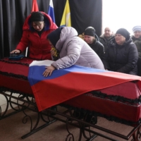 Family and friends attend the funeral of a Ukrainian serviceman who was killed in clashes with the Russian military on Thursday. | AFP-JIJI