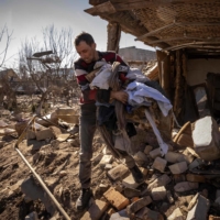 A man collects belongings from a damaged house in the city of Zhytomyr, Ukraine, on Wednesday. | AFP-JIJI