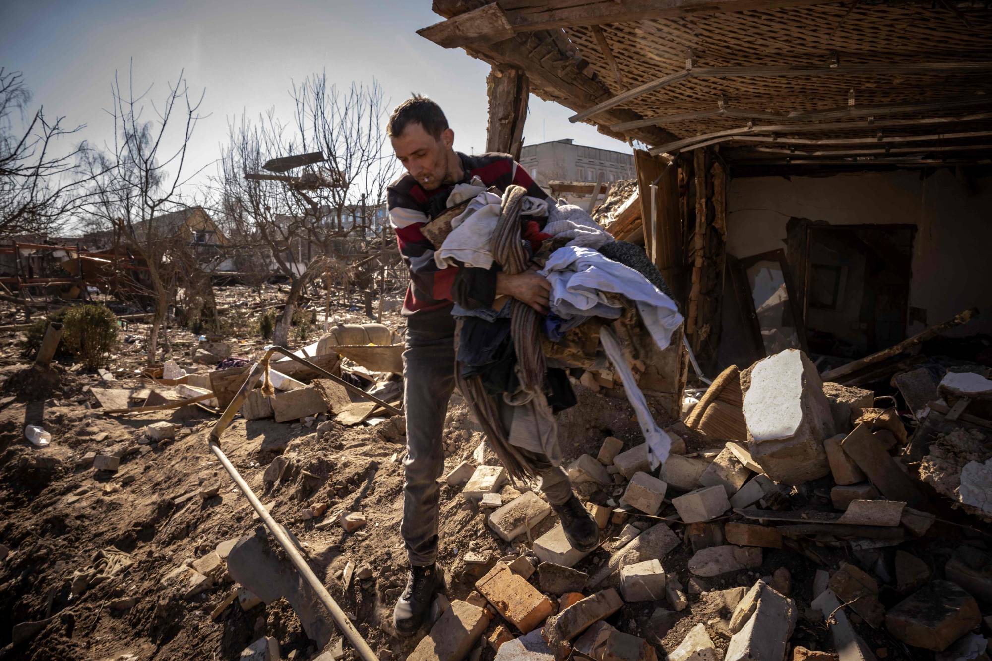 A man collects belongings from a damaged house in the city of Zhytomyr, Ukraine, on Wednesday. | AFP-JIJI