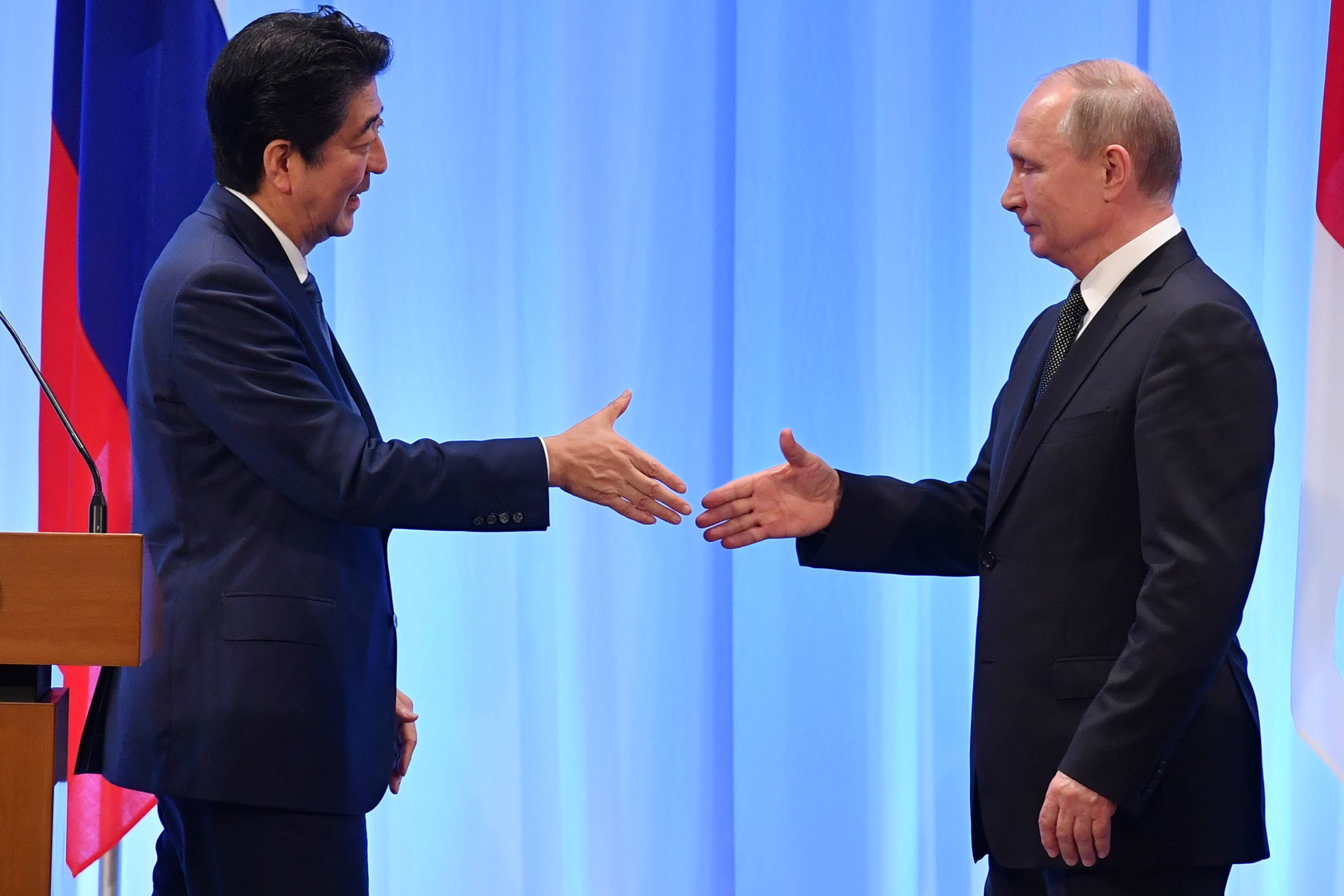 Prime Minister Shinzo Abe meets with Russian President Vladimir Putin at the Group of 20 Summit in Osaka in June 2019. It's time for Tokyo to acknowledge Moscow’s behavior for what it has always been: empty rhetoric, tactical tricks and bullying. | POOL VIA / REUTERS