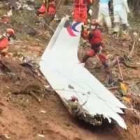 Screengrab of rescue teams with a piece of the fuselage as they continue their search at the site of where a China Eastern passenger jet crashed onto a mountainside near Wuzhou in China\'s southern Guangxi region. | AFP-JIJI