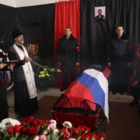 People attend a farewell ceremony for Sergei Sokolov, the 21 year-old serviceman who was killed during Russian military action in Ukraine, in the settlement of Zubkovo, in Russia\'s Novosibirsk region, on Thursday. | AFP-JIJI