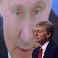 Kremlin spokesman Dmitry Peskov sits in front of a screen displaying Russian President Vladimir Putin. Peskov said last week that Russia would only use nuclear weapons in the context of Ukraine conflict if it were facing an \"existential threat.\" | AFP-JIJI