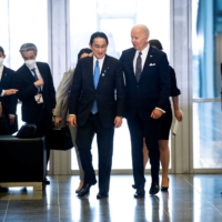 Prime Minister Fumio Kishida and U.S. President Joe Biden walk from a meeting to the G7 family photo at NATO Headquarters in Brussels on Thursday. | POOL / VIA REUTERS
