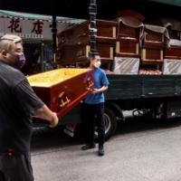 Empty coffins are delivered to a funeral services shop and funeral parlors in the Kowloon district of Hong Kong on March 17 amid the soaring death toll in the city as a result of COVID-19. | AFP-JIJI