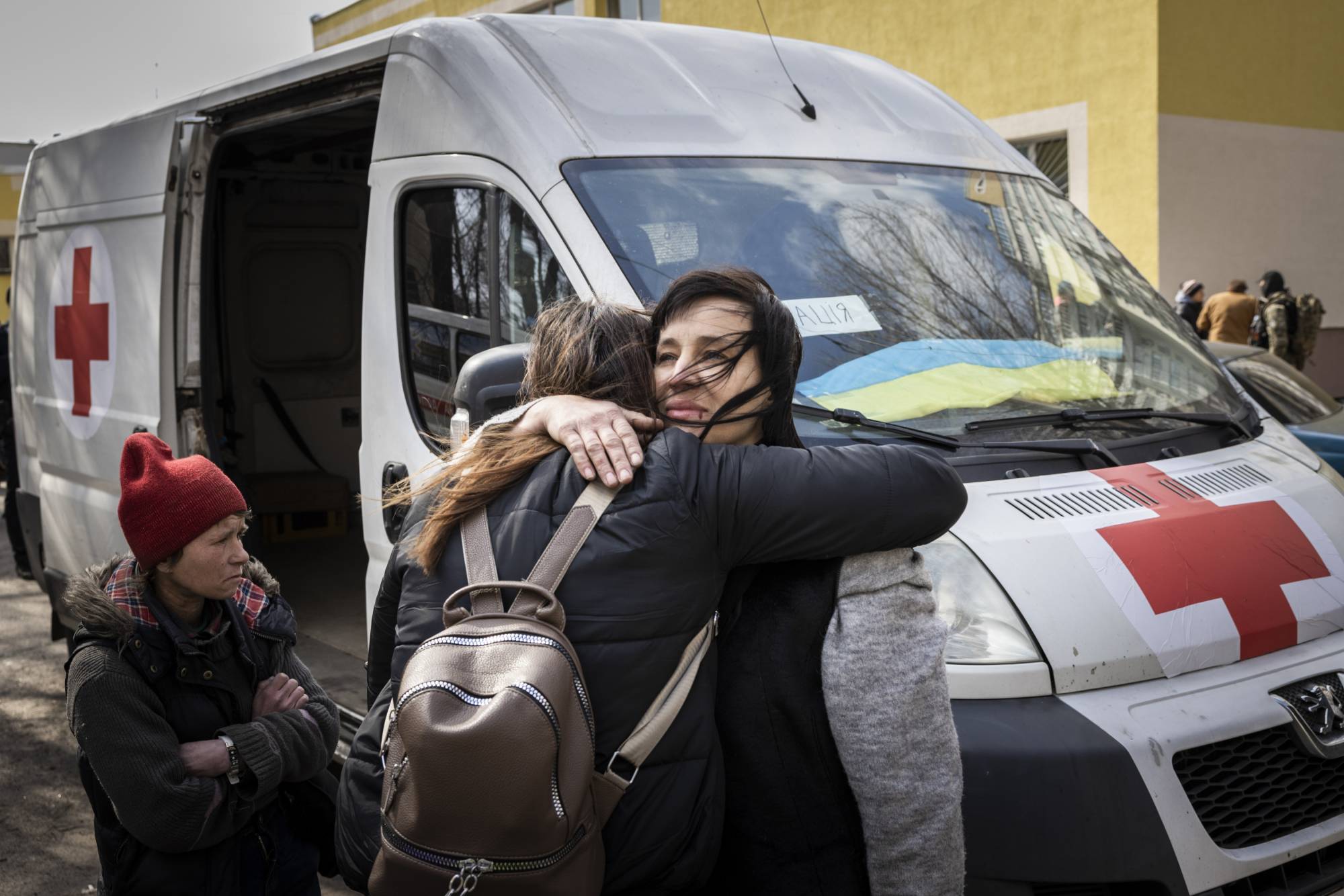 People embrace at an aid station on the outskirts of Kyiv, after evacuating Irpin, Ukraine, on March 24. | Ivor Prickett / The New York Times
