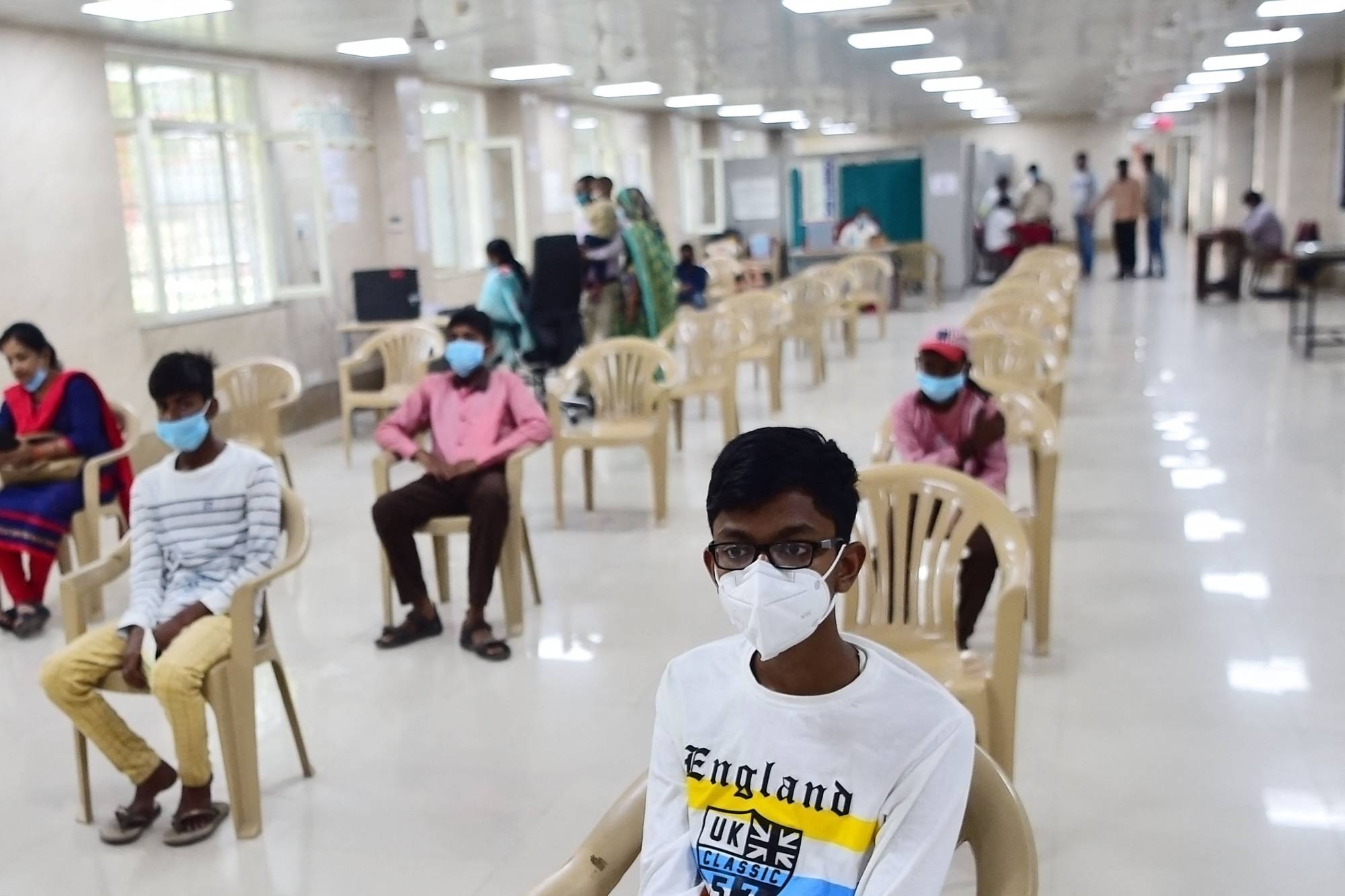 Young people wait to receive a dose of a COVID-19 vaccine in Allahabad, India, on March 16. | AFP-Jiji