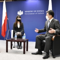 Justice Minister Yoshihisa Furukawa (right) meets with Polish Ambassador to Japan Pawel Milewski at the Justice Ministry on Wednesday. | KYODO