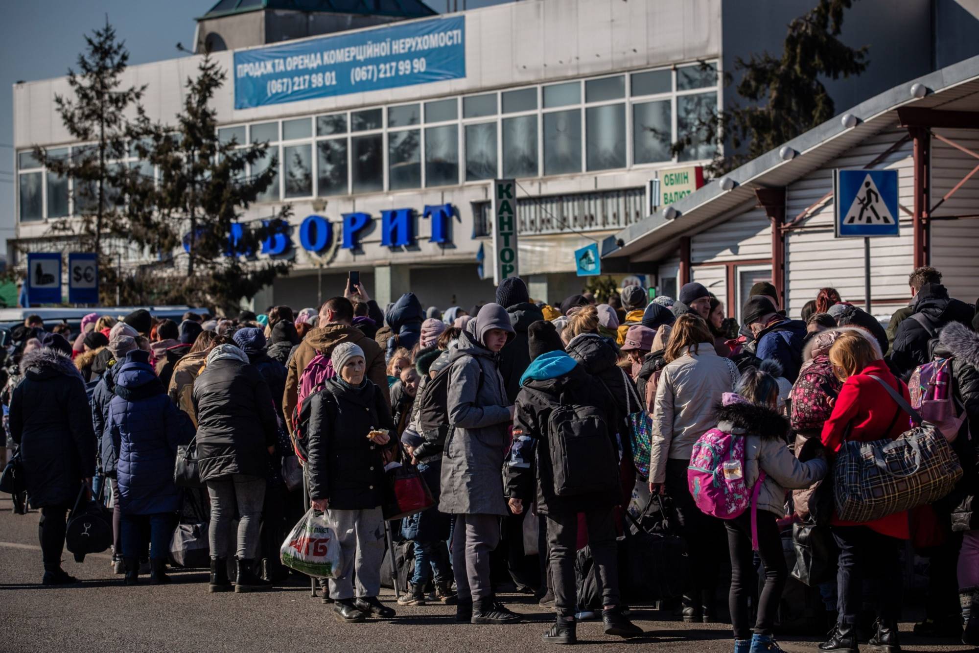 Ukrainian refugees queue to cross over into Poland via the Medyka border crossing in Shehyni, Ukraine, on March 18. | BLOOMBERG