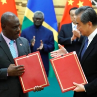 Chinese State Councillor and Foreign Minister Wang Yi and his Solomon Islands counterpart, Jeremiah Manele, attend a signing ceremony at the Great Hall of the People in Beijing in October 2019. | REUTERS