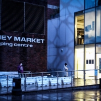 People wait outside a COVID-19 testing center in London late last year. England stopped giving free coronavirus tests to most people on Friday, a landmark moment in the government\'s decision to live with the virus even as cases have surged in the past month. | MARY TURNER / THE NEW YORK TIMES