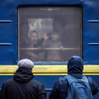 Children wave from a train in Kramatorsk as families flee the eastern city in Ukraine\'s Donbas region on Monday amid the Russian invasion of the country. | AFP-JIJI