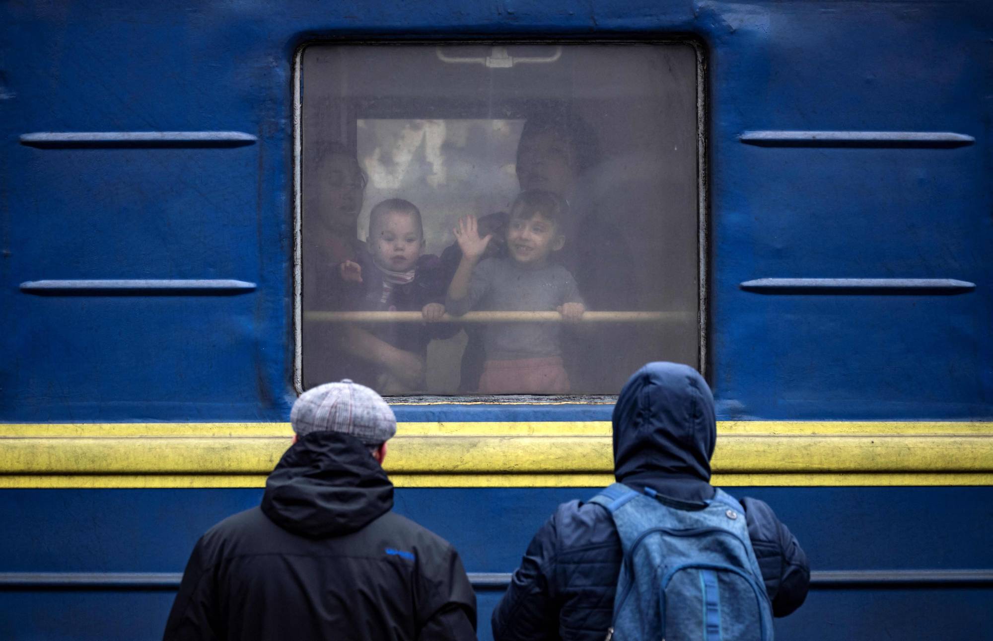 Children wave from a train in Kramatorsk as families flee the eastern city in Ukraine's Donbas region on Monday amid the Russian invasion of the country. | AFP-JIJI