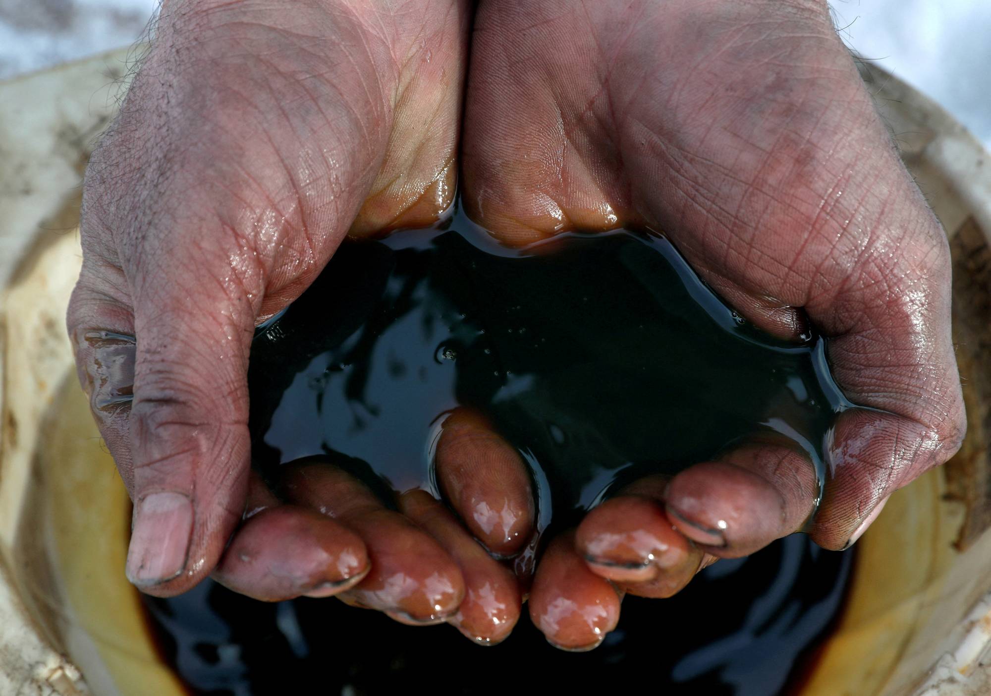 An employee holds a sample of crude oil at the Yarakta oilfield in the Irkutsk region of Russia.  | REUTERS