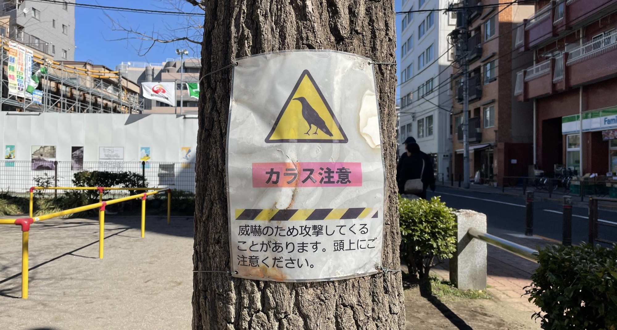 A warning sign at a park in Tokyo's Bunkyo Ward asks pedestrians to be careful of crows. | ALEX K.T. MARTIN 