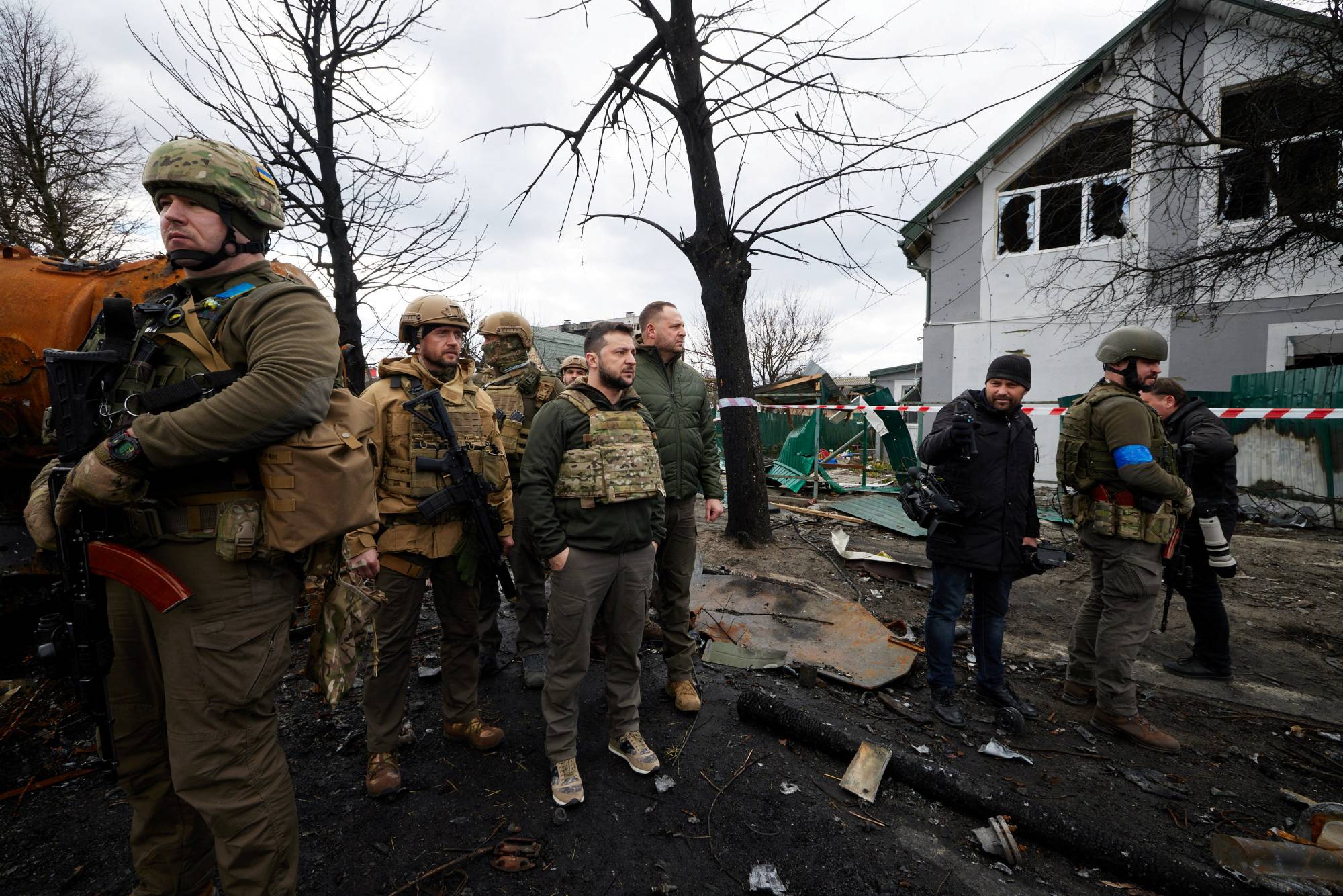 Ukrainian President Volodymyr Zelenskyy stands next to destroyed Russian military vehicles in Bucha, outside Kyiv, on Monday.  | UKRAINIAN PRESIDENTIAL PRESS SERVICE / VIA REUTERS