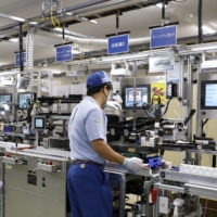 An employee assembles a battery module at a plant of Kanazu Murata Manufacturing Co., an affiliate of Murata Manufacturing Co., in Awara, Fukui Prefecture, operated entirely on renewable energy. | BLOOMBERG
