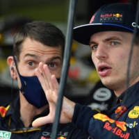 Red Bull driver Max Verstappen (right) talks to a crew member during the first practice session ahead of the Australian Grand Prix in Melbourne on Friday. | AFP-JIJI