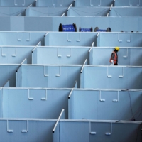 A worker converts the National Exhibition and Convention Center into a makeshift hospital for COVID-19 in Shanghai on Thursday. | REUTERS 