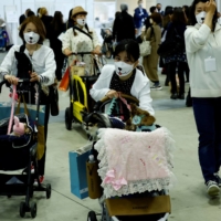 People visit Interpets, an international fair for pet-related products and services, in Tokyo on March 31. The government has said that no matter what variants are detected in Japan, basic prevention measures like wearing masks will remain the same. | REUTERS