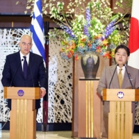 Greek Foreign Minister Nikos Dendias (left) and his Japanese counterpart Yoshimasa Hayashi attend a joint news conference on April 13 in Tokyo. | POOL / VIA KYODO