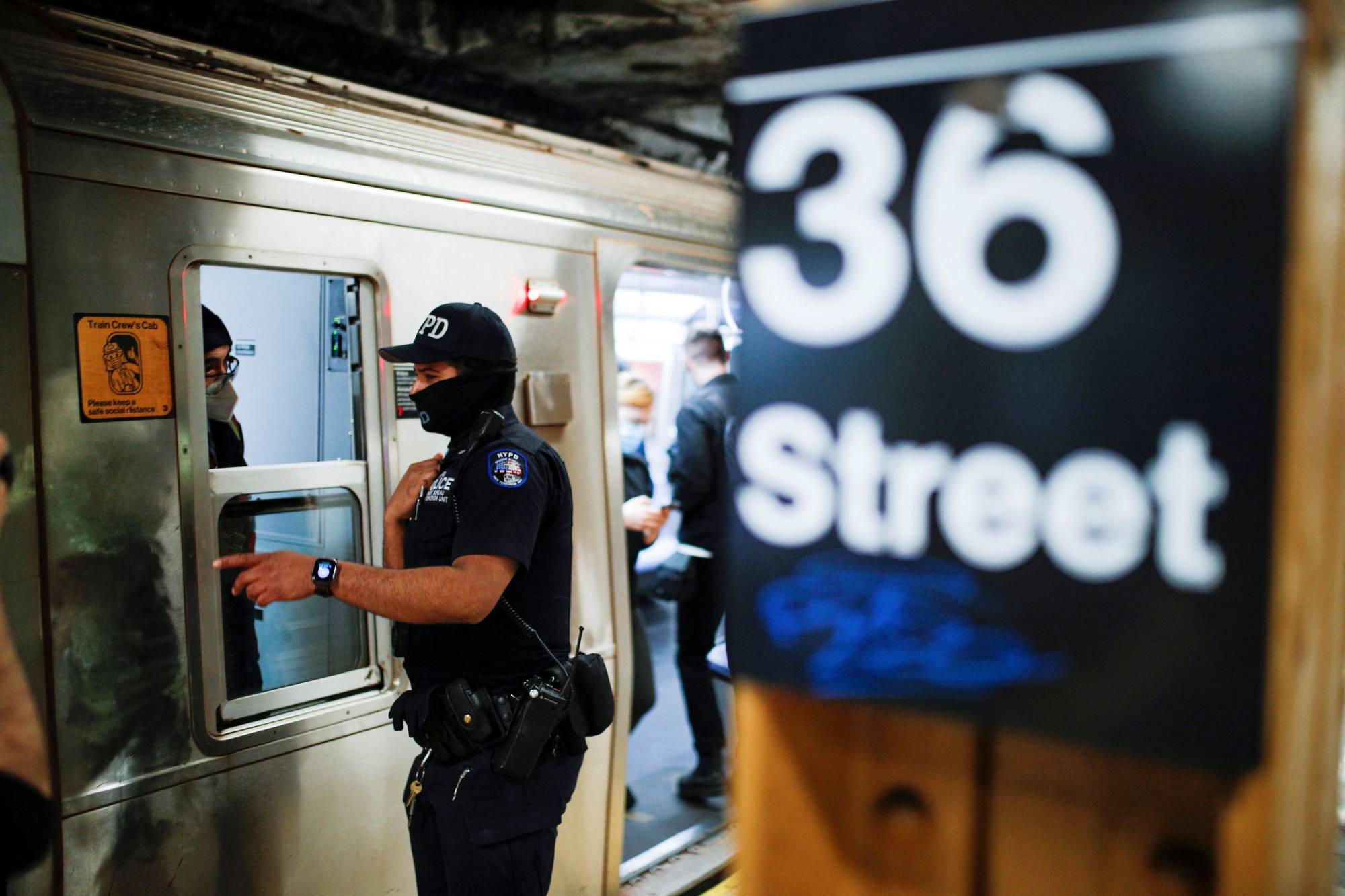 A police officer speaks with an MTA worker as he patrols the 36th Street subway station in New York on Wednesday.  | Reuters 